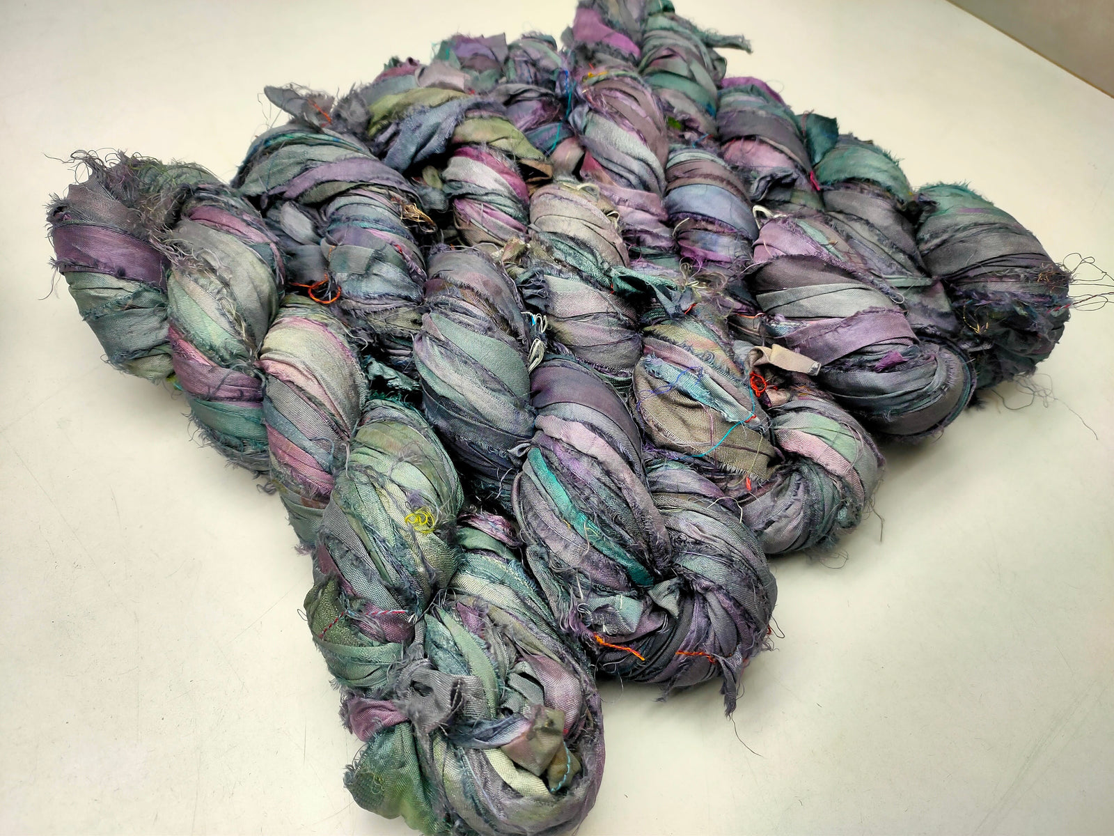 Recycled Sari silk Ribbon is the by-product of colorful saris that women wear in India. It is the loose ends of saris collected from industrial mills in India that is torn in stripes and sewn end 