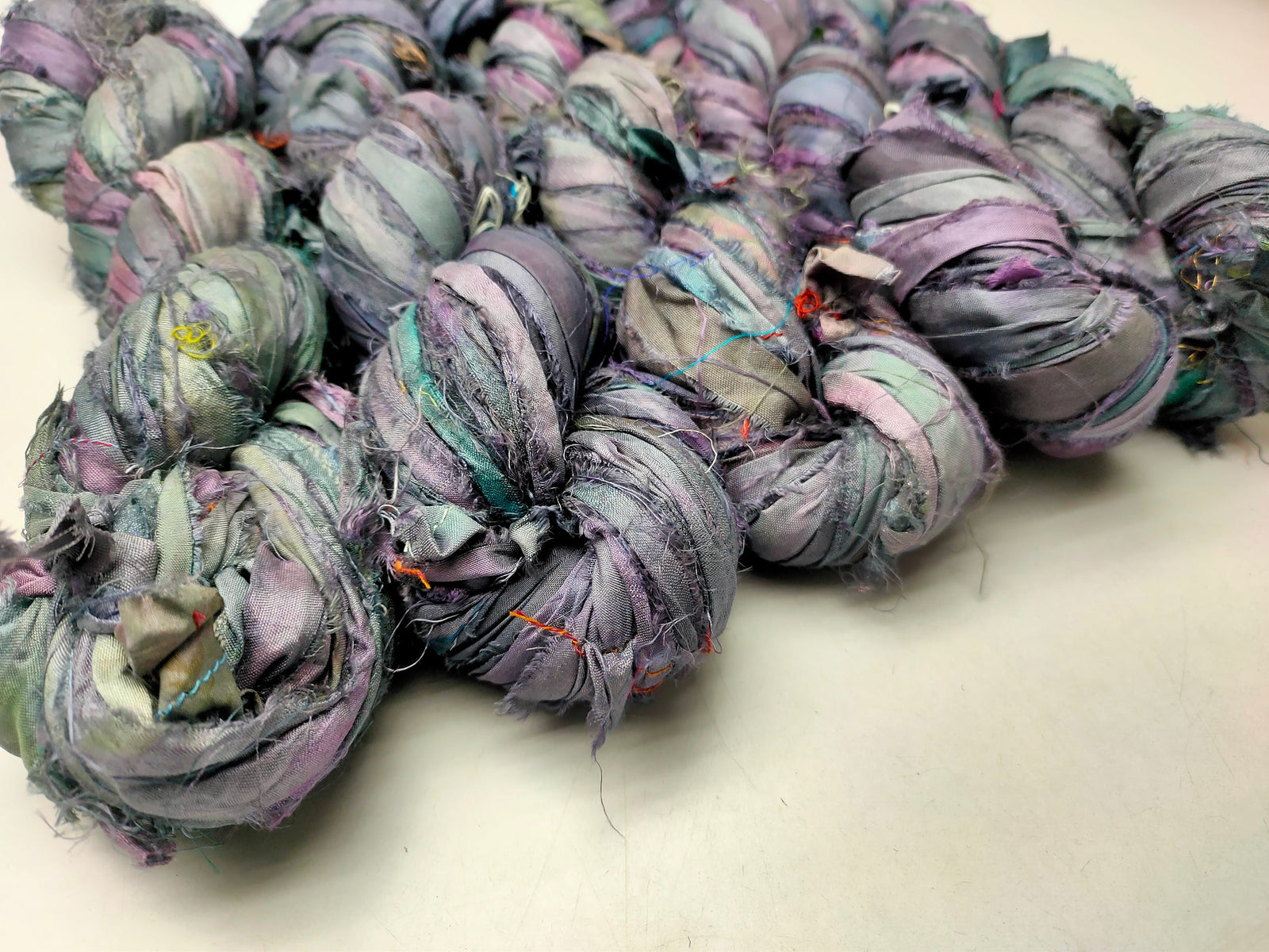 Recycled Sari silk Ribbon is the by-product of colorful saris that women wear in India. It is the loose ends of saris collected from industrial mills in India that is torn in stripes and sewn end 