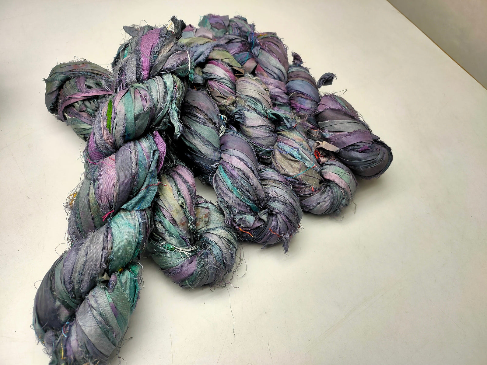 Recycled Sari silk Ribbon is the by-product of colorful saris that women wear in India. It is the loose ends of saris collected from industrial mills in India that is torn in stripes and sewn end 
