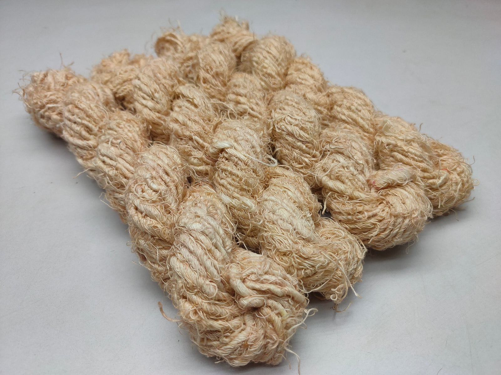 Recycled Linen Yarn Beigi is made from leftover or excessive warp/ weft thread on handlooms / powerloom, to be specific the byproduct linen from industrial Linen weaving unit in India. The yarn is hand-spun, using drop spindle helping women cooperatives to earn their livelihood.