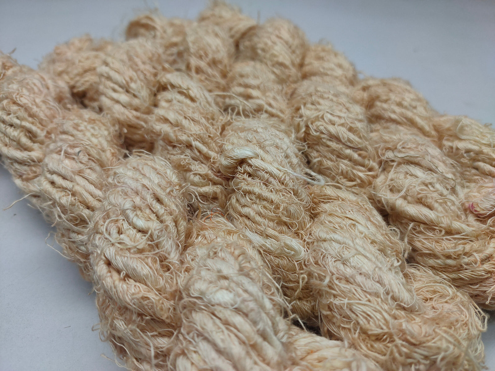 Recycled Linen Yarn Beigi is made from leftover or excessive warp/ weft thread on handlooms / powerloom, to be specific the byproduct linen from industrial Linen weaving unit in India. The yarn is hand-spun, using drop spindle helping women cooperatives to earn their livelihood.