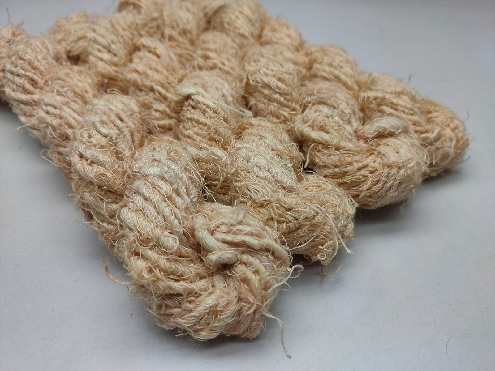 Recycled Linen Yarn Beigi is made from leftover or excessive warp/ weft thread on handlooms / powerloom, to be specific the byproduct linen from industrial Linen weaving unit in India. The yarn is hand-spun, using drop spindle helping women cooperatives to earn their livelihood.