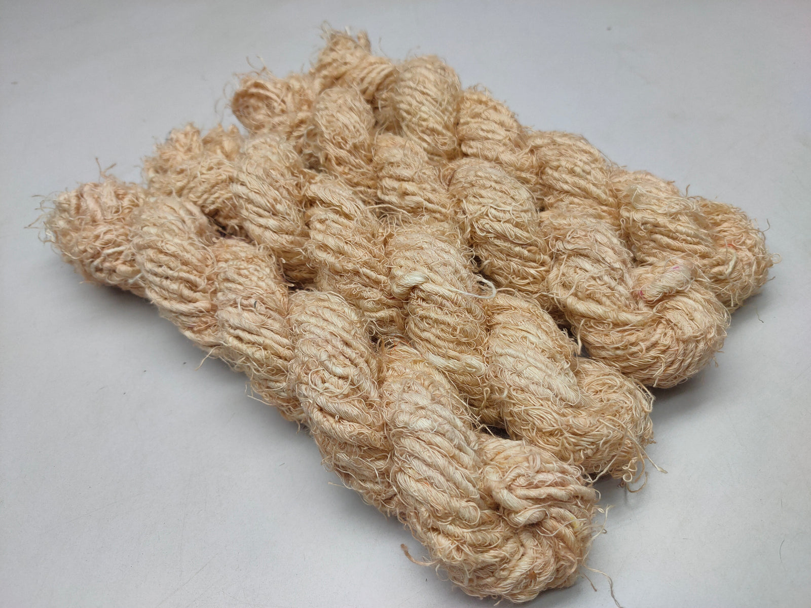 Recycled Linen Yarn Beigi is made from leftover or excessive warp/ weft thread on handlooms / powerloom, to be specific the byproduct linen from industrial Linen weaving unit in India. The yarn is hand-spun, using drop spindle helping women cooperatives to earn their livelihood.