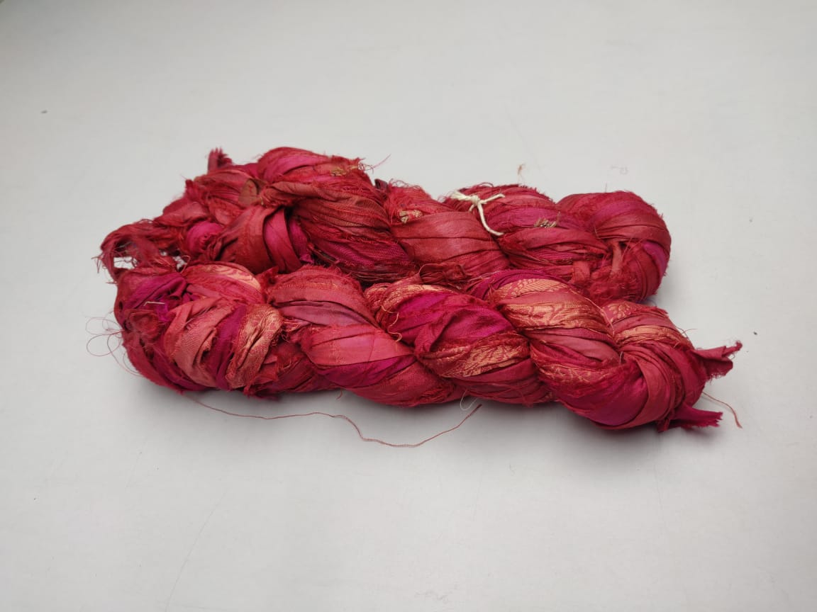 Recycled Sari Silk Ribbon-Brick is the by-product of colorful saris that women wear in India. It is the loose ends of saris collected from industrial mills in India that is torn in stripes and sewn end to end to make beautiful and colorful ribbons. The vibrant colors and unique texture of these silk fabric, the sari silk ribbons are inspirational to designers, knitters, and artisans.