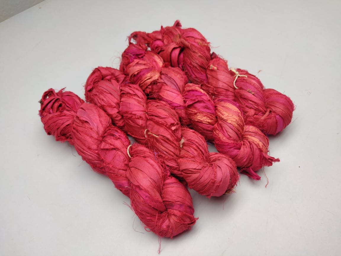 Recycled Sari Silk Ribbon-Brick is the by-product of colorful saris that women wear in India. It is the loose ends of saris collected from industrial mills in India that is torn in stripes and sewn end to end to make beautiful and colorful ribbons. The vibrant colors and unique texture of these silk fabric, the sari silk ribbons are inspirational to designers, knitters, and artisans.