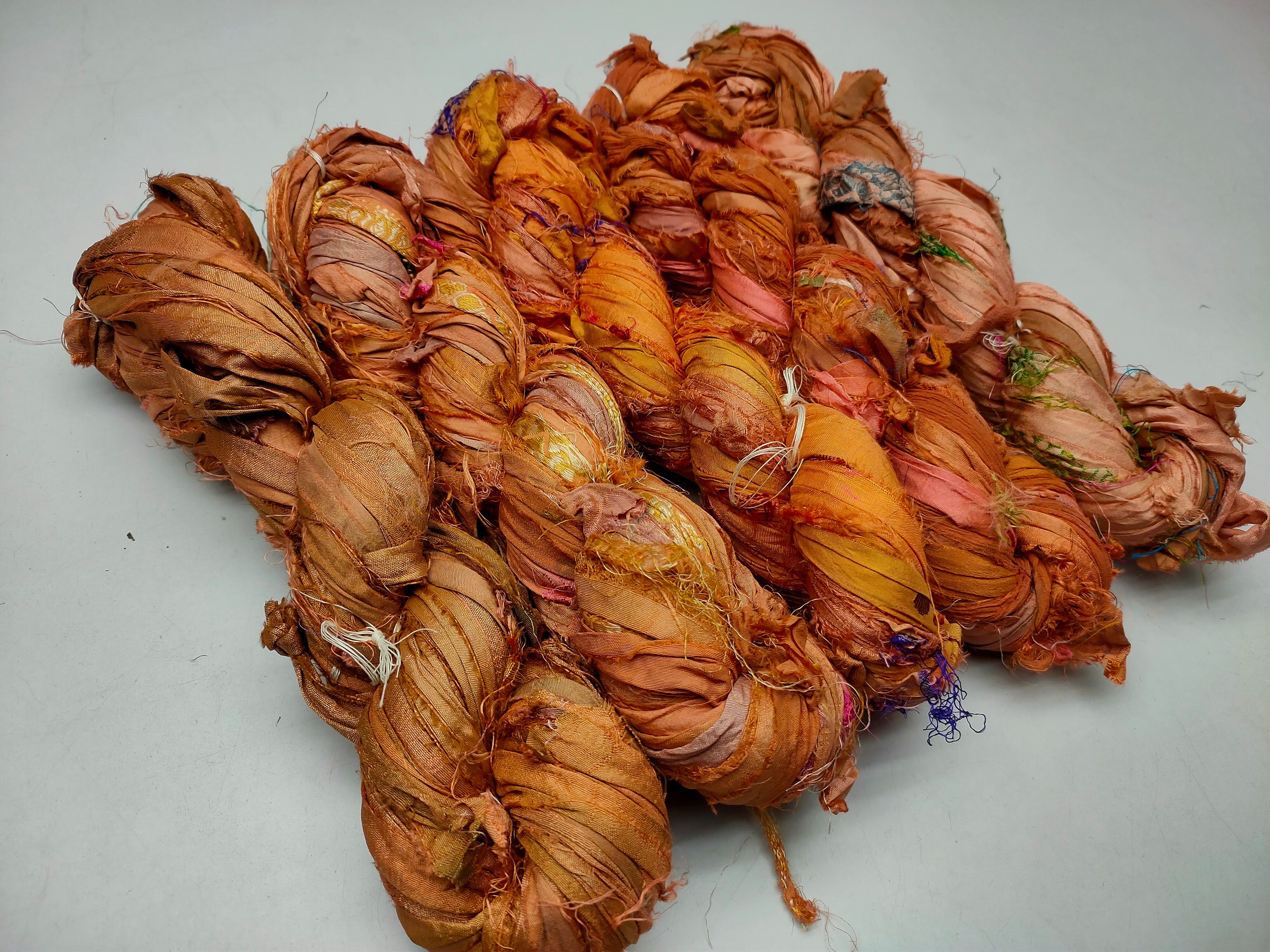 Recycled Sari silk Ribbon is the by-product of colorful saris that women wear in India. It is the loose ends of saris collected from industrial mills in India that is torn in stripes and sewn end to end to make beautiful and colorful ribbons. The vibrant colors and unique texture of these silk fabric, the Recycles sari ribbon are inspirational to designers, knitters, and artisans. 