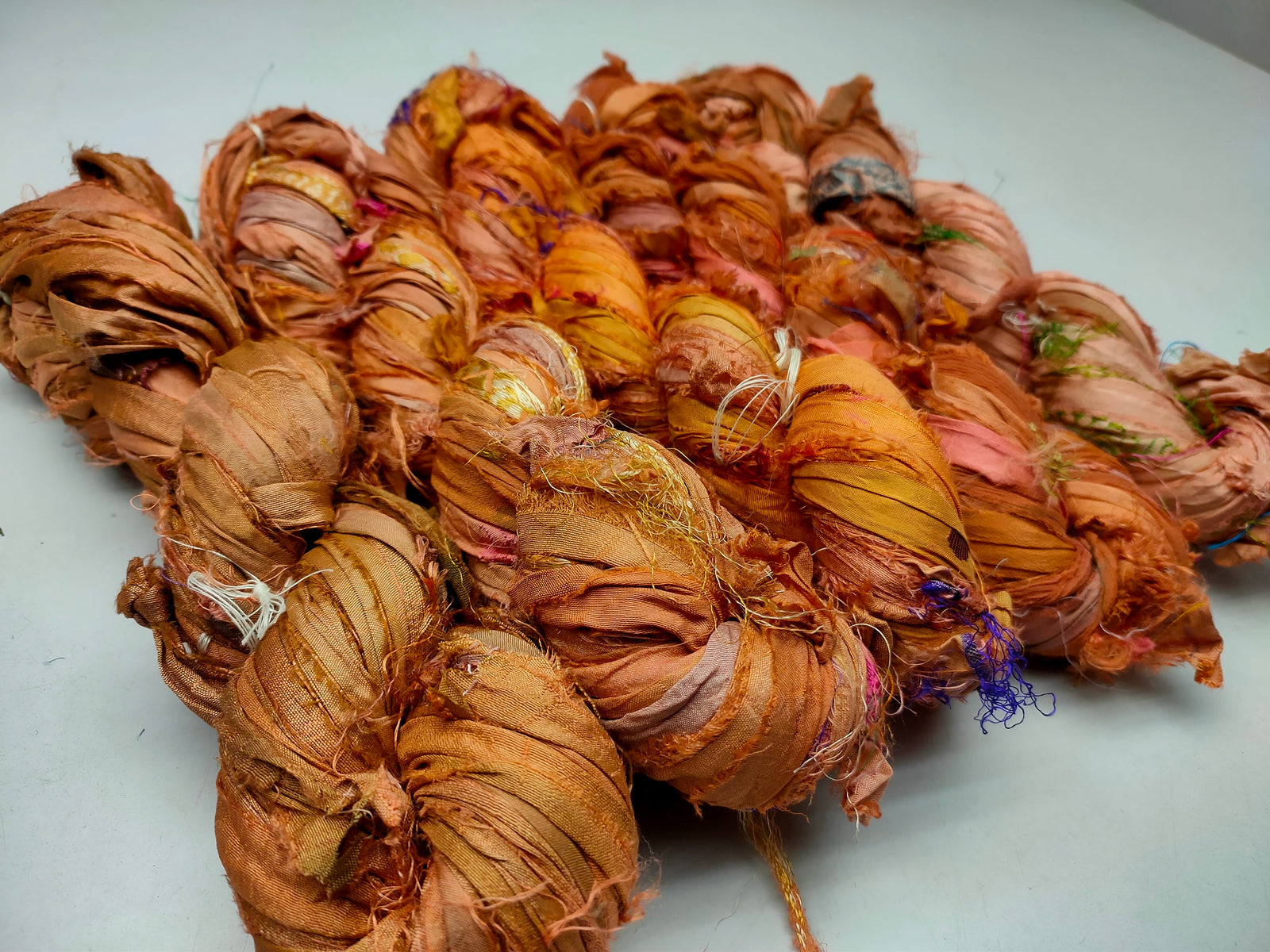 Recycled Sari silk Ribbon is the by-product of colorful saris that women wear in India. It is the loose ends of saris collected from industrial mills in India that is torn in stripes and sewn end to end to make beautiful and colorful ribbons. The vibrant colors and unique texture of these silk fabric, the Recycles sari ribbon are inspirational to designers, knitters, and artisans. 