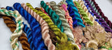 Sari Silk Fiber - Jewels Tone is available in assorted colorways, and is braided! They are the strongest natural roving fibers and are spun into a wonderful yarn used for knitting and weaving! The Colorful Sari Silk Thrums have a lovely draping quality. The fiber is a smooth filament and the fabric out of it is comfortable against the skin. Silk is a natural protein fiber. These roving fibers are well known for its shine, lustre and tensile strength.