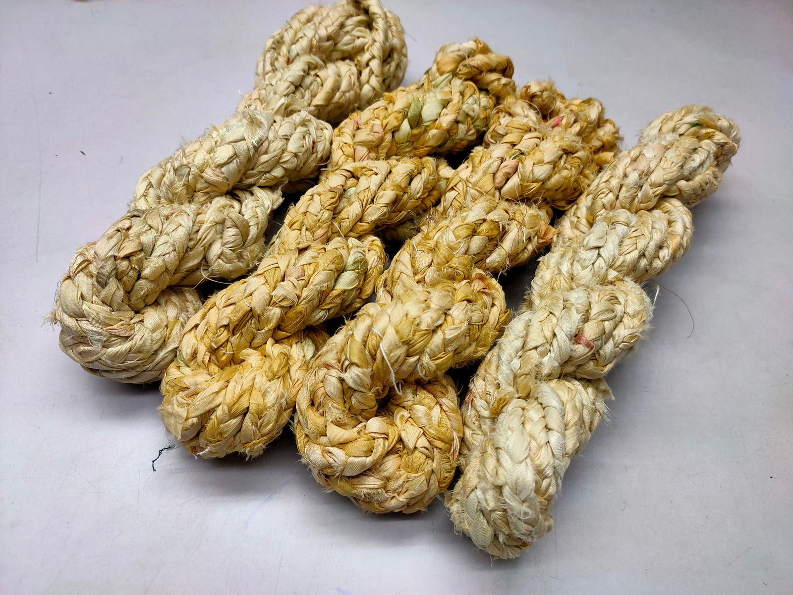 Braided yarn is made of pure silk and is approximately an inch wide through out. Due to its handmade nature there might occasionally be variations in width. When silk fabric is cut and made into saris, wraps, and veils, there is always a bit left over. Rather than throw that waste fiber into the trash, it has been made into a beautiful, unique, soft yarn..!! Direct from India, this yarn is a truly recycled product. It is a bulky weight and is soft and easy to knit or crochet.