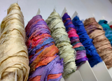 Recycled Sari silk Ribbon is the by-product of colorful saris that women wear in India. It is the loose ends of saris collected from industrial mills in India that is torn in stripes and sewn end to end to make beautiful and colorful ribbons. The vibrant colors and unique texture of these silk fabric, the sari silk ribbons are inspirational to designers, knitters, and artisans.