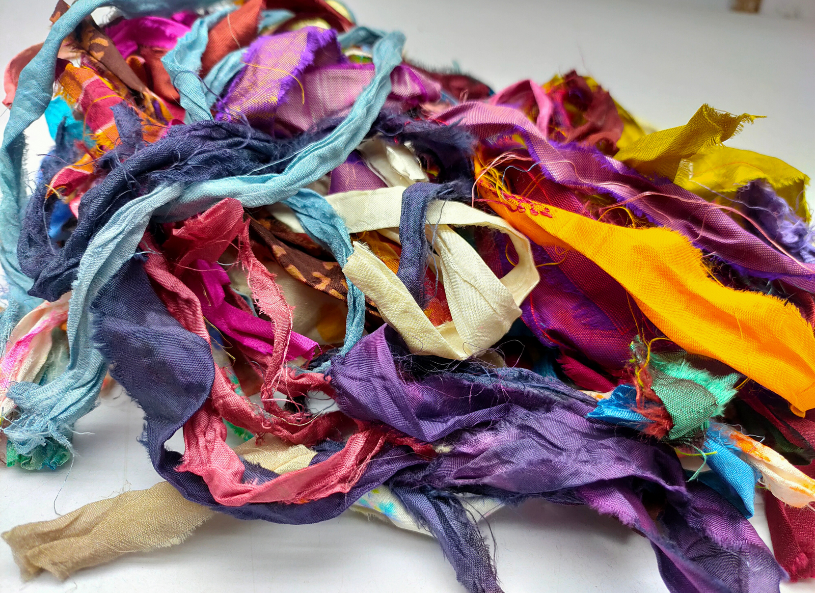 This ribbons scraps is made of completely recycled Sari material from recycled clothing. We work with women’s Cooperative in the countryside to produce this unique ribbons and other hand knitted silk yarn products. Women make this ribbons and various knitwear in their homes while not neglecting their other household chores. This work provides additional income to support and improve their family earnings.