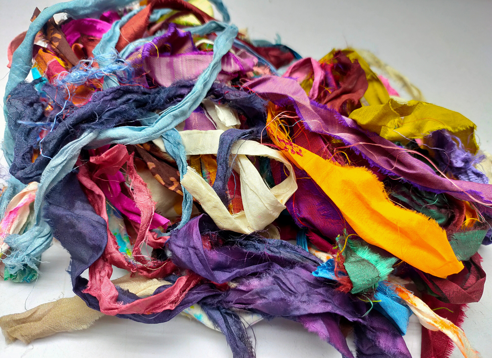 This ribbons scraps is made of completely recycled Sari material from recycled clothing. We work with women’s Cooperative in the countryside to produce this unique ribbons and other hand knitted silk yarn products. Women make this ribbons and various knitwear in their homes while not neglecting their other household chores. This work provides additional income to support and improve their family earnings.