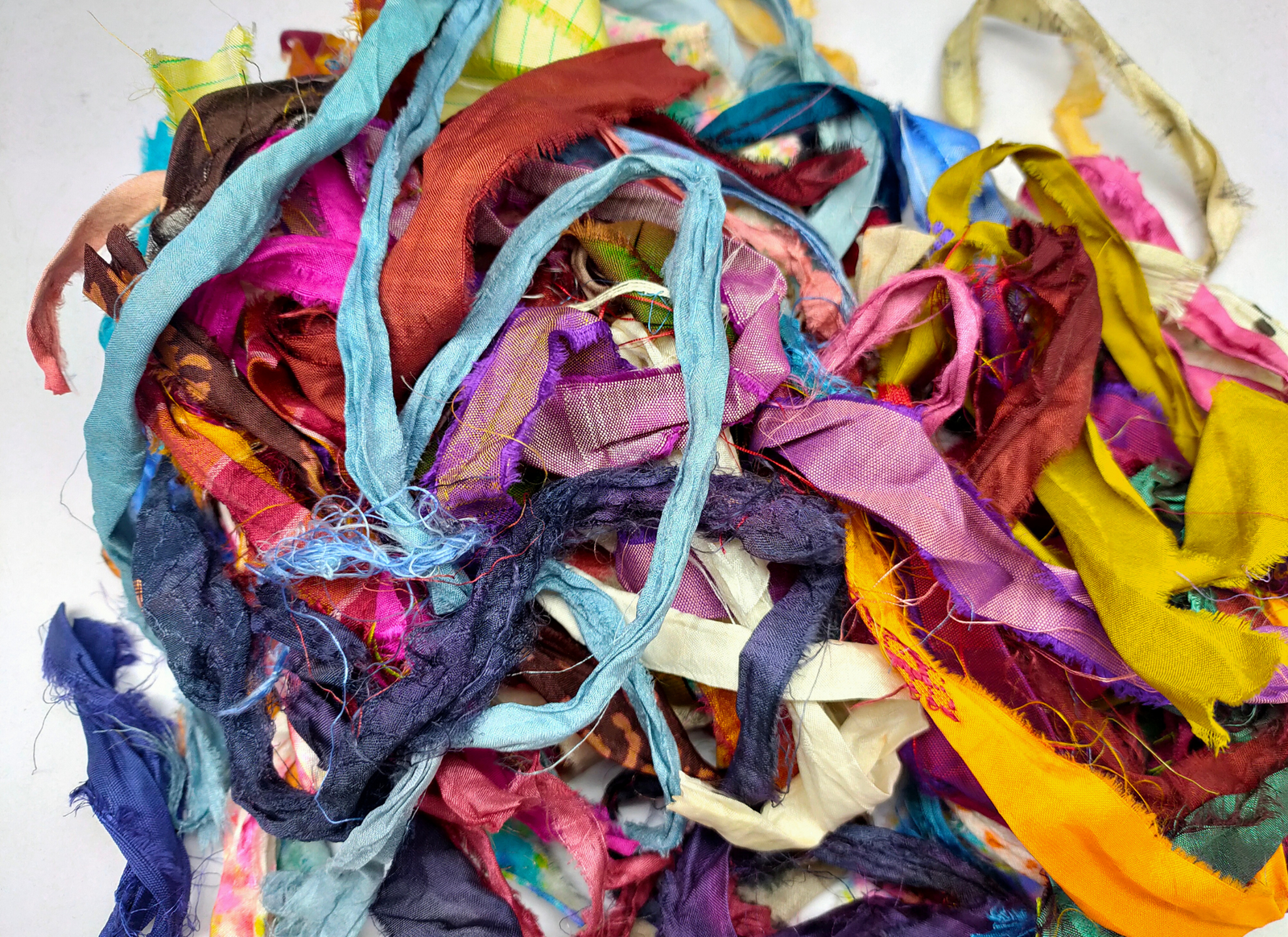 This ribbons scraps is made of completely recycled Sari material from recycled clothing. We work with women’s Cooperative in the countryside to produce this unique ribbons and other hand knitted silk yarn products. Women make this ribbons and various knitwear in their homes while not neglecting their other household chores. This work provides additional income to support and improve their family earnings.