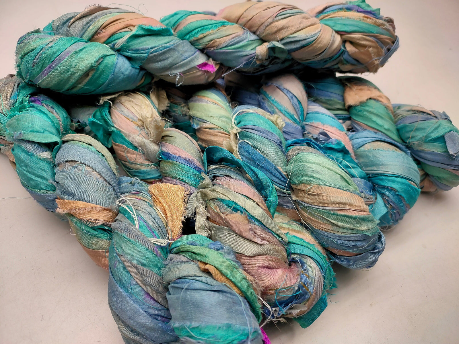 Recycled Sari silk Ribbon is the by-product of colorful saris that women wear in India. It is the loose ends of saris collected from industrial mills in India that is torn in stripes and sewn end to end to make beautiful and colorful ribbons. 