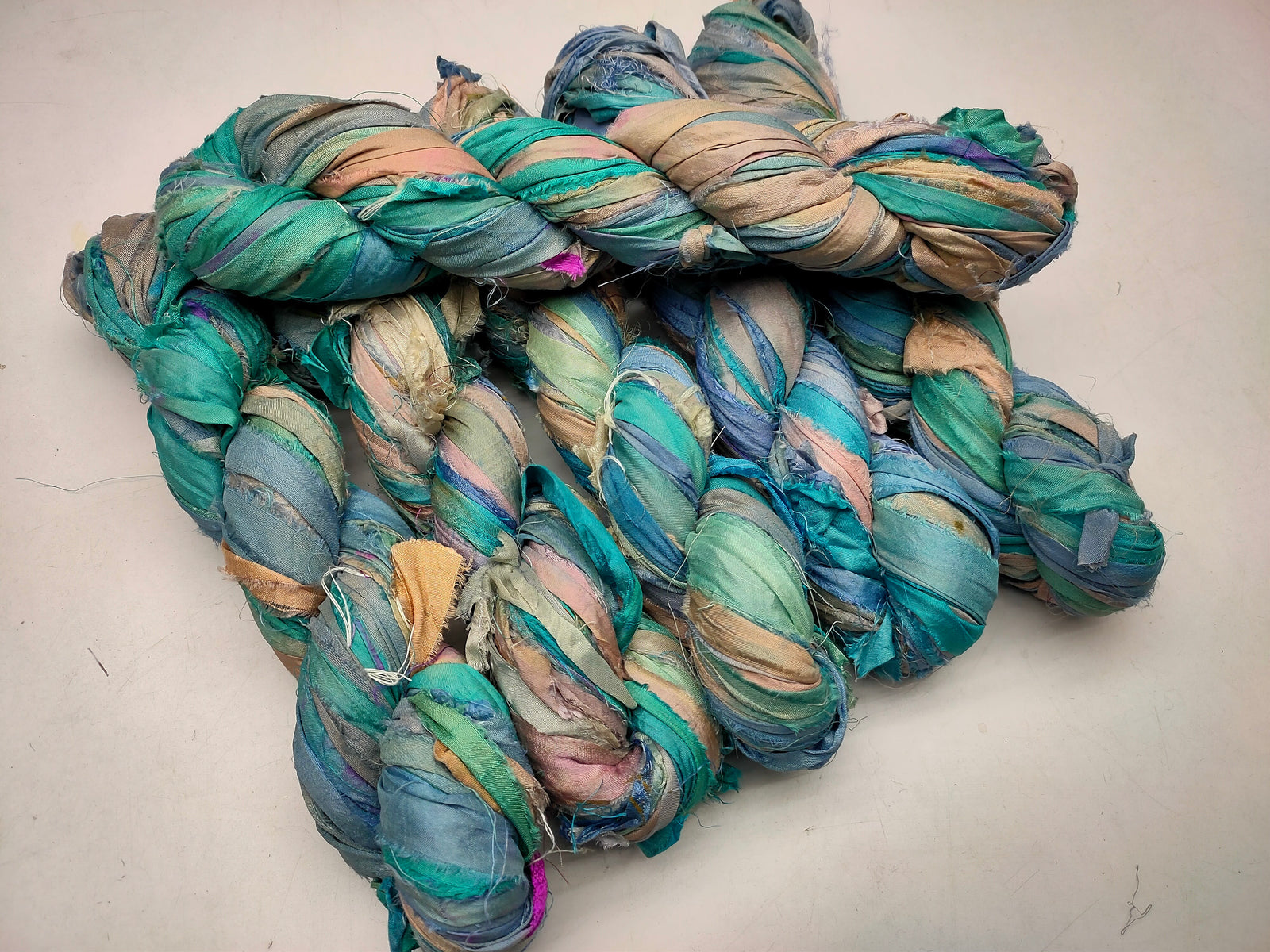 Recycled Sari silk Ribbon is the by-product of colorful saris that women wear in India. It is the loose ends of saris collected from industrial mills in India that is torn in stripes and sewn end to end to make beautiful and colorful ribbons. 