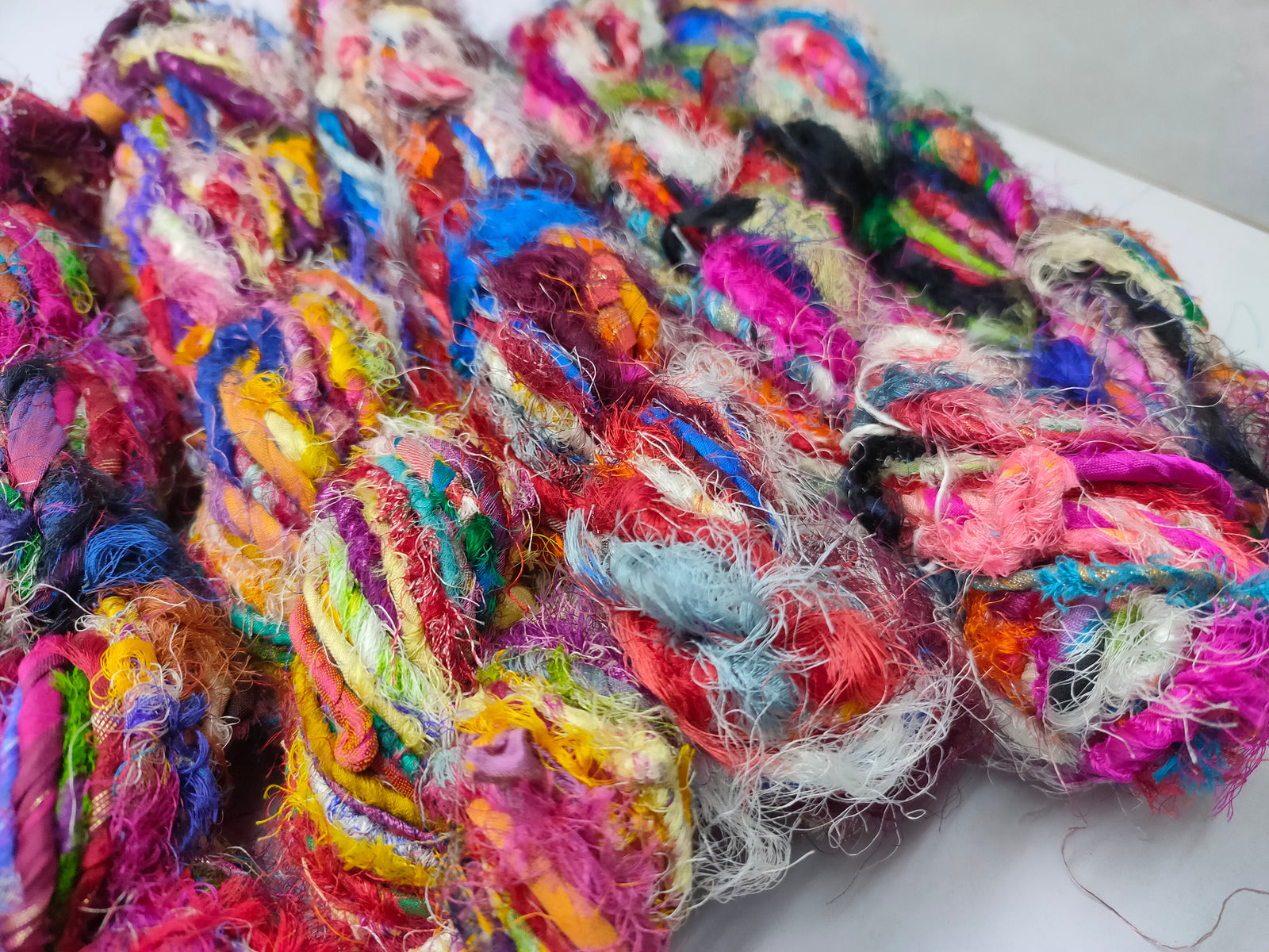 Recycled Sari Silk Yarn - Carded - SilkRouteIndia - Recycled Sari Silk Yarn - Carded is available in multitude of colors, and being premium, you get extra length of yarn in the same weight. We fabricate Recycle Sari Silk Yarn from the bi-product of sari and silk production units. The Yarn, available with us, is hand spun into bright hanks which is suitable for number of Handicrafts applications.