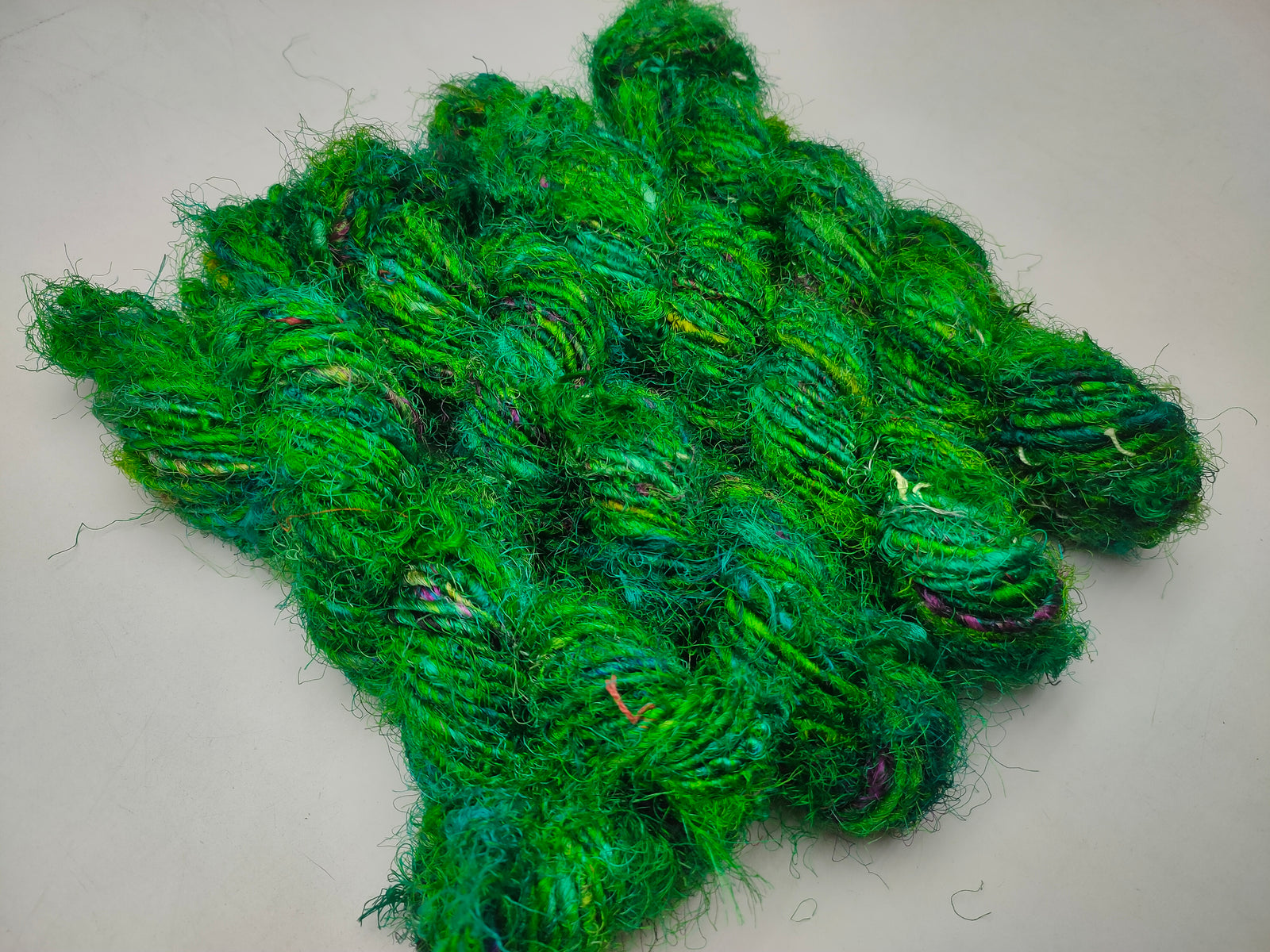 Recycled Sari Silk Yarn Green - SilkRouteIndia - Recycled Sari Silk Yarn is available in multitude of colors, and being premium, you get extra length of yarn in the same weight. We fabricate Recycle Sari Silk Yarn from the bi-product of sari and silk production units. The Yarn, available with us, is hand spun into bright hanks 