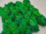 Recycled Sari Silk Yarn Green - SilkRouteIndia- Recycled Sari Silk Yarn is available in multitude of colors, and being premium, you get extra length of yarn in the same weight. We fabricate Recycle Sari Silk Yarn from the bi-product of sari and silk production units. The Yarn, available with us, is hand spun into bright hanks 