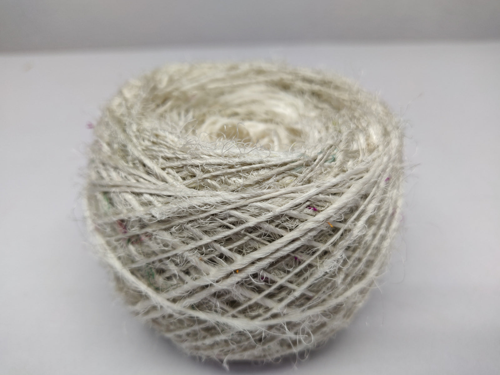 Recycled Sari Silk Yarn Prime Balls White - SilkRouteIndia Recycled Sari Silk Yarn(Prime*) that is available in multitude of colors, and being prime, you get extra length of yarn in the same weight. We fabricate Recycled Sari Silk Yarn(Prime*) from the bi-product of sari and silk production units. The Yarn, available with me, is hand spun into bright hanks initially and later is been converted to Balls which is suitable for number of Handicrafts applications.