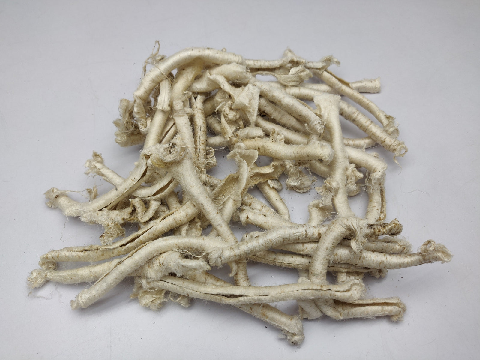 Mulberry Silk Carrier Rods - SilkRouteIndia- Carrier Rods are a waste product in the silk spinning industry. Perfect for surface texture during felting and can be dyed as per need. If you sprinkle it with water and iron them flat then you can create a sort of silk paper. Original pieces will be criss cross or slightly twisted. Use them in your felting, create unique and interesting jewelry, textural stitching and silk fusion. 